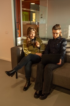 Two business partners discussing ideas over coffee in a cozy office space.