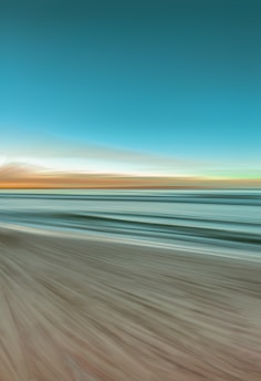 A serene ocean scene blending blue and green hues with soft cream accents.