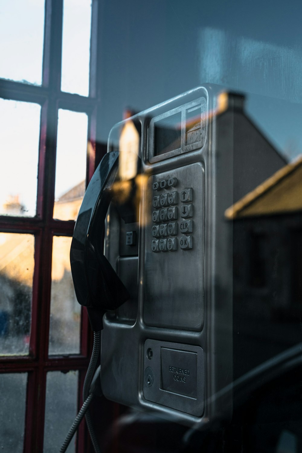 an old fashioned telephone is reflected in a window