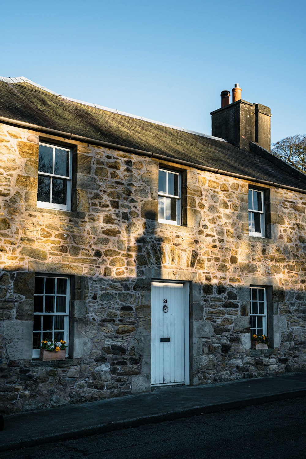 a stone building with a white door and windows