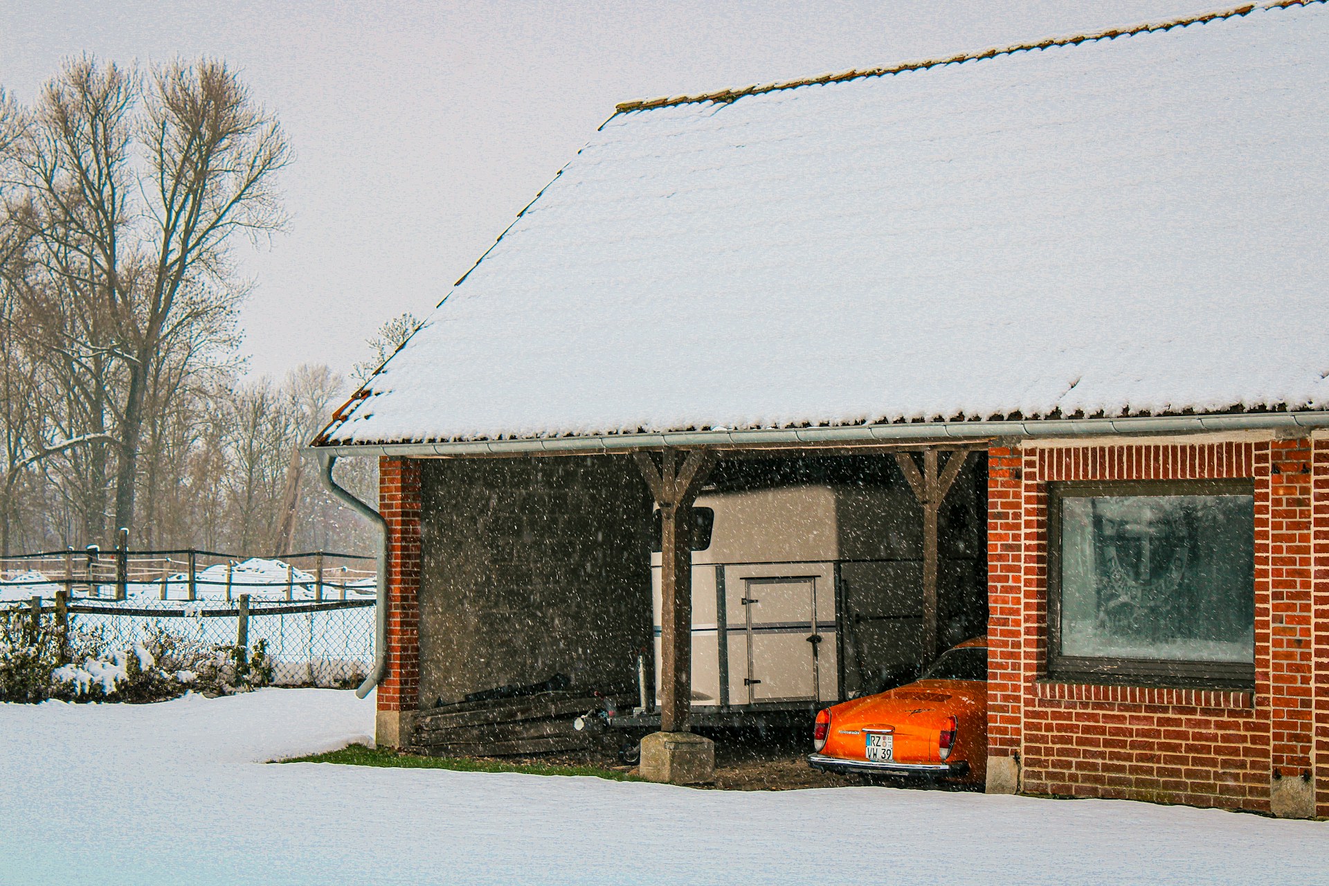 an orange car is parked in front of a brick building