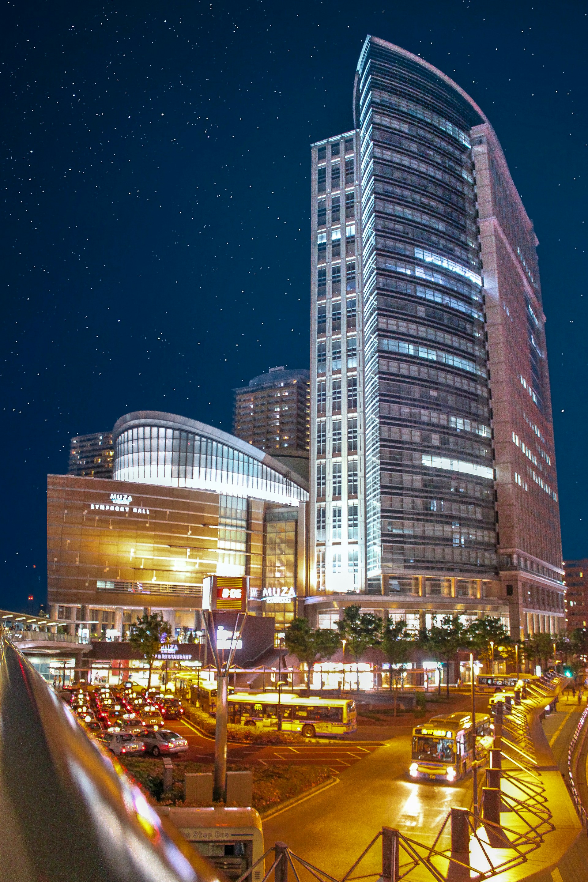 A vibrant cityscape of Warsaw at dusk with glowing lights and modern buildings.