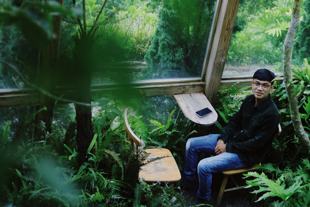 a man sitting in a chair in a forest