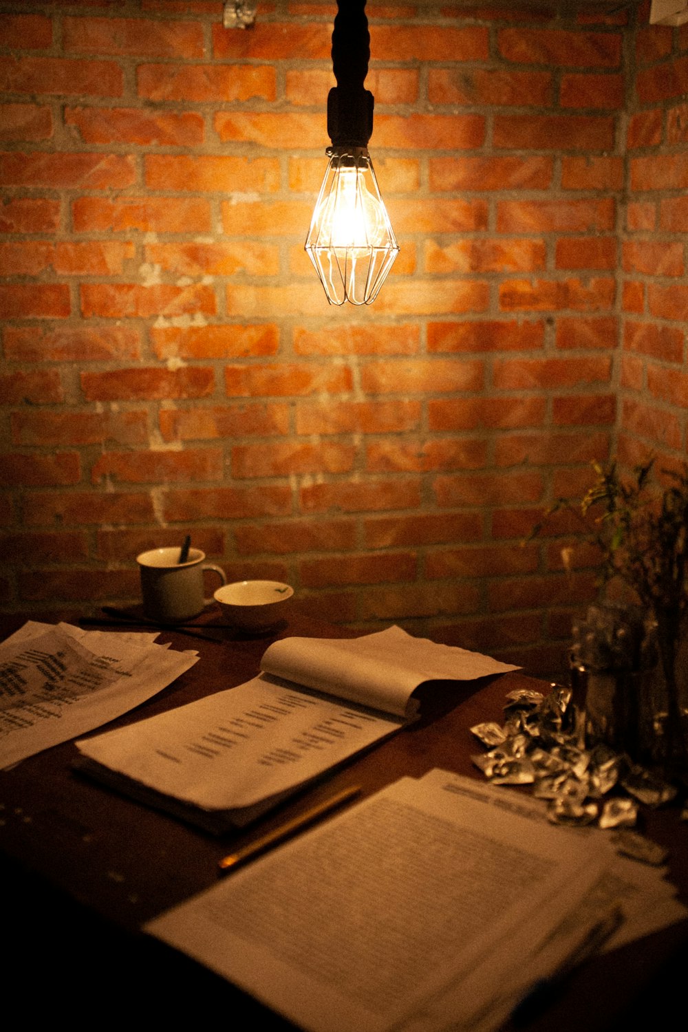a light bulb hanging over a table with papers on it