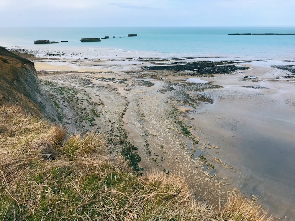 a sandy beach next to a body of water