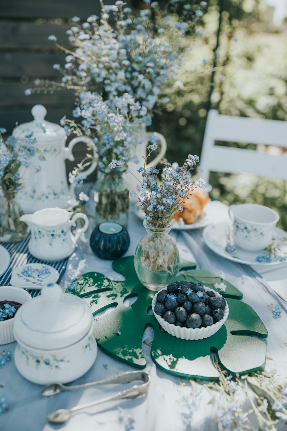 a table topped with plates and bowls filled with blueberries