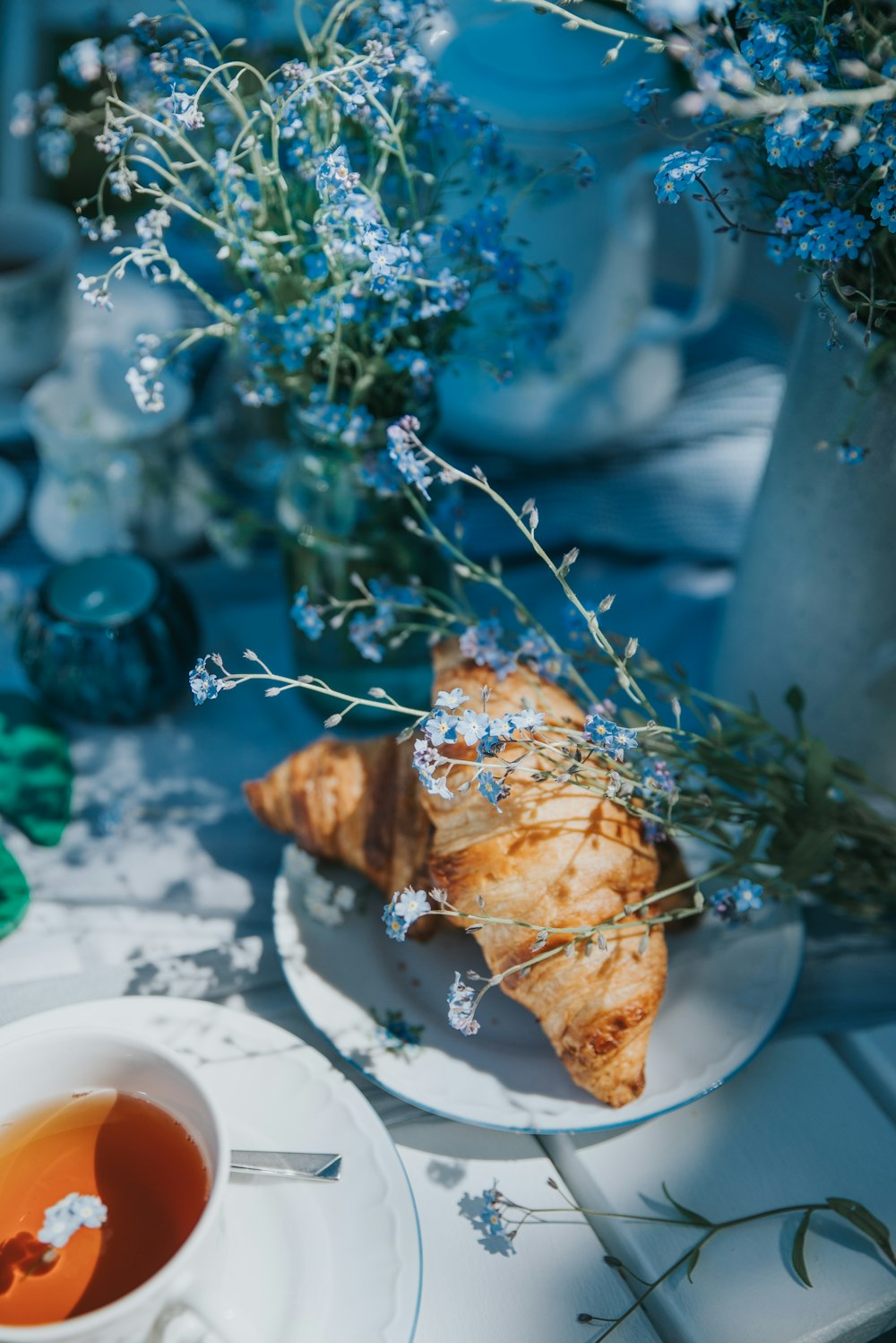 a cup of tea and a croissant on a table