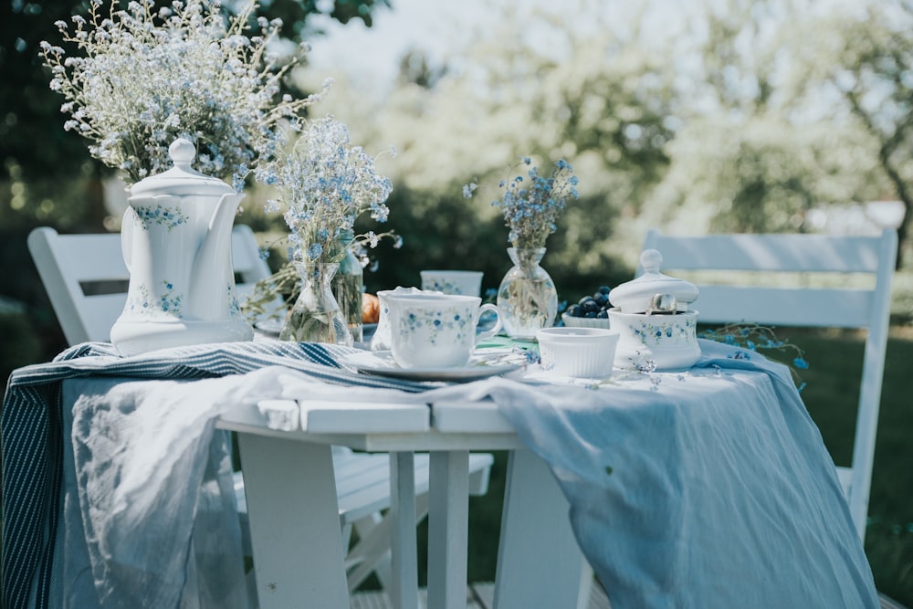 a table with a blue table cloth and vases on it
