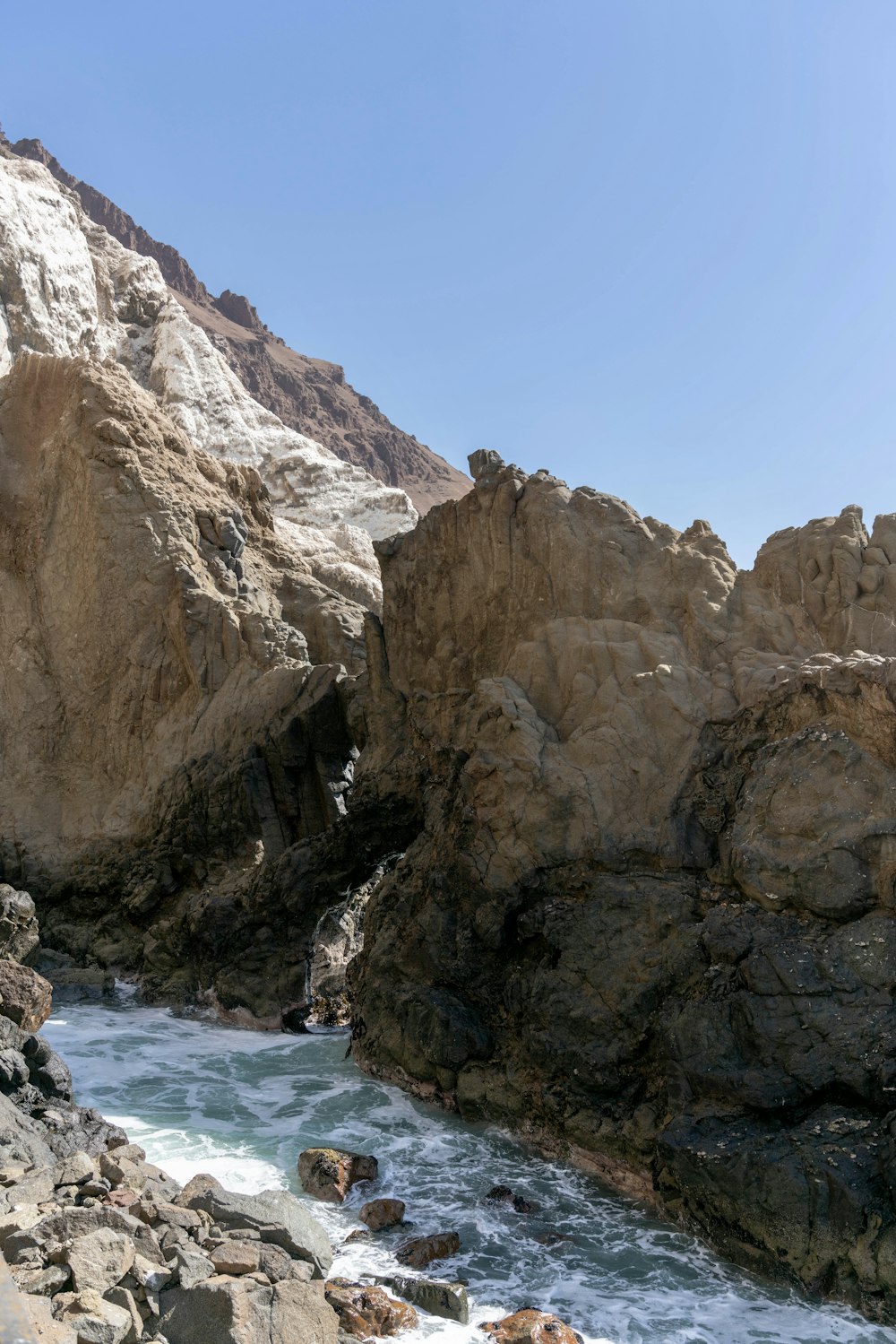 a rocky cliff with a river running between it