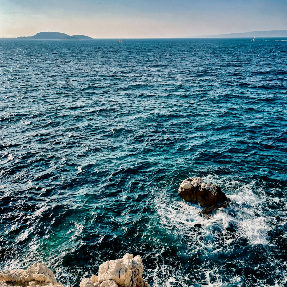 a large body of water with rocks in the foreground