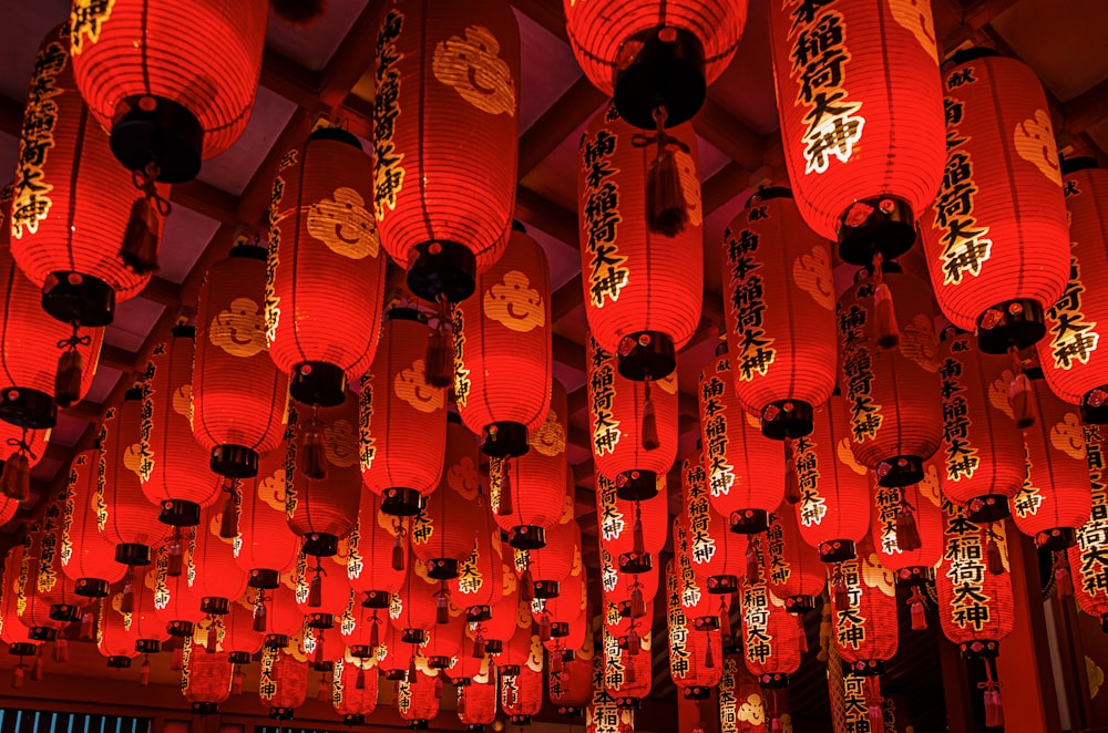 a room filled with lots of red lanterns hanging from the ceiling