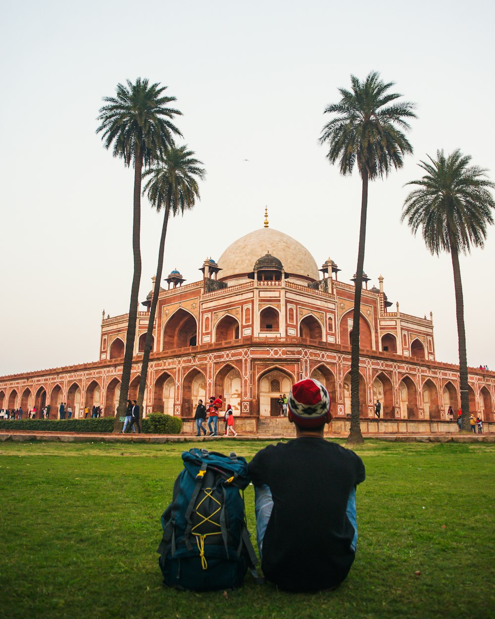 a man sitting on the grass in front of a building