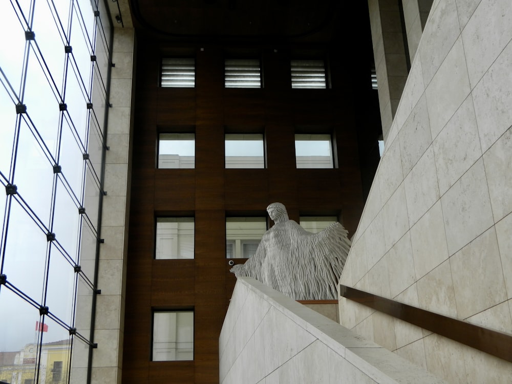 Una statua di un uccello su una sporgenza accanto a un edificio