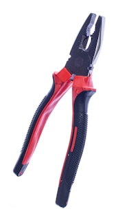 A pair of pliers with black handles featuring red accents. The handles have a textured grip for better handling, and the jaws are made for gripping and twisting wires or small objects.
