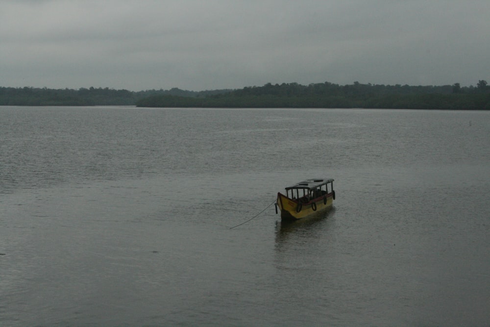 a yellow boat floating on top of a large body of water