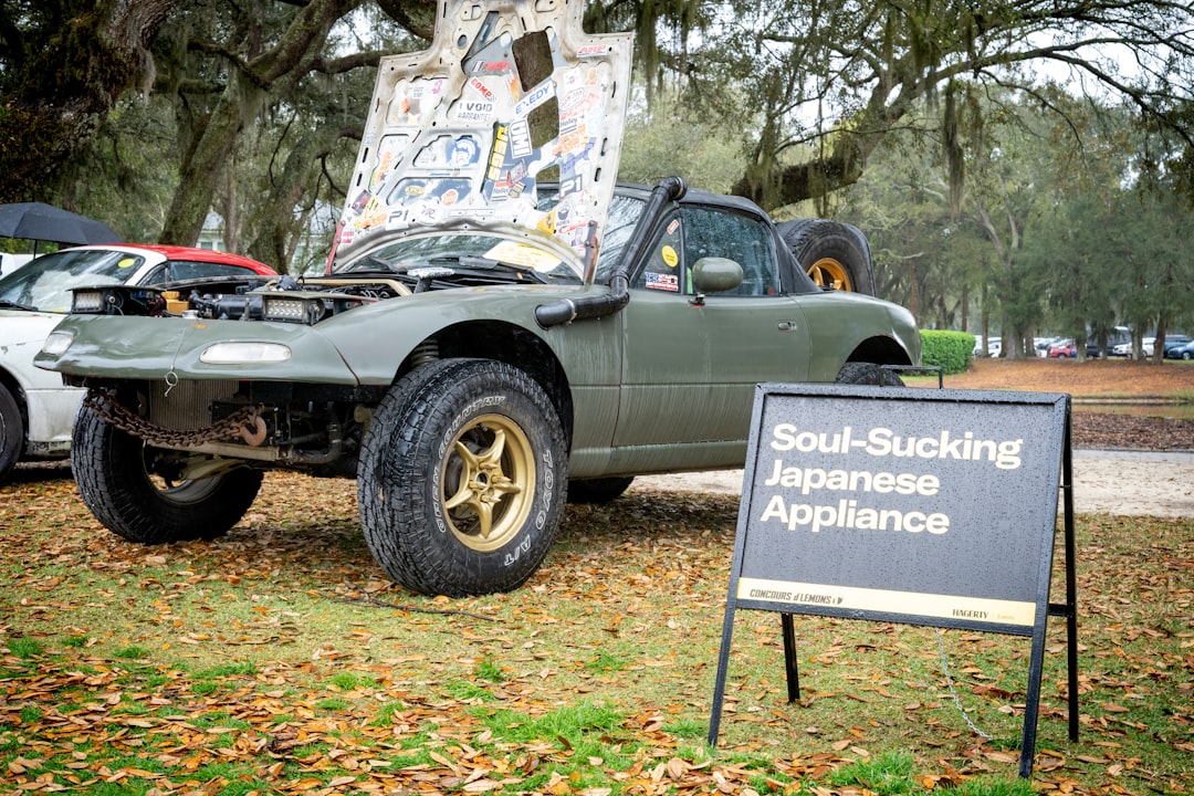 a truck parked in the grass with a sign in front of it,