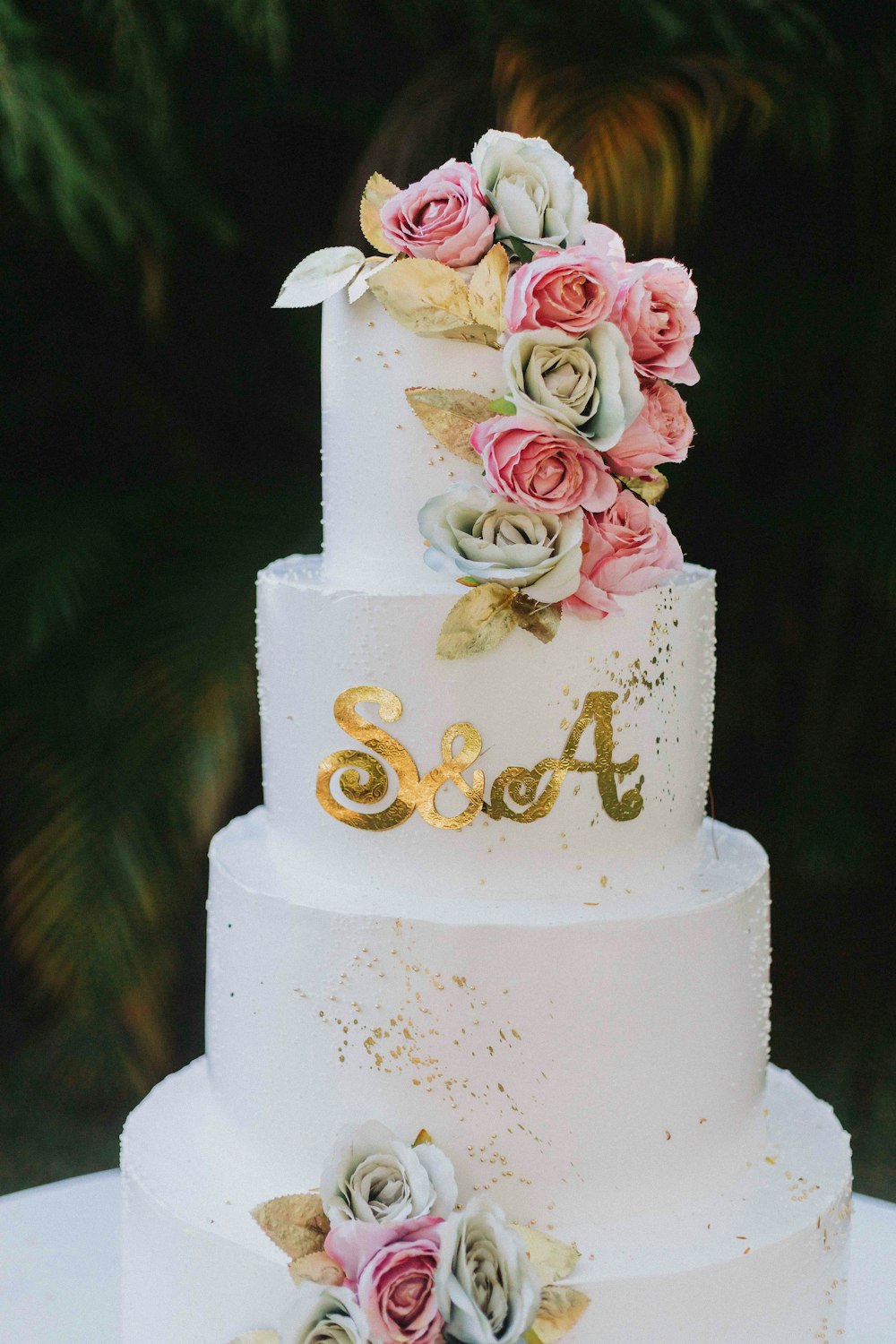a white wedding cake with pink and gold flowers