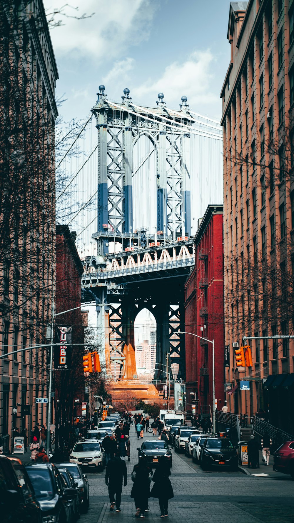 a group of people walking down a street next to tall buildings