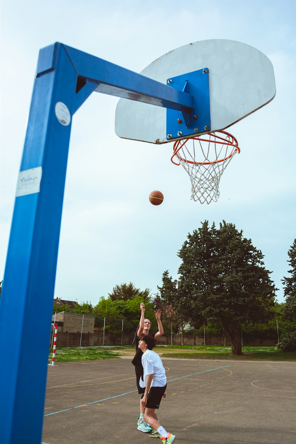 two young boys playing basketball on a basketball court