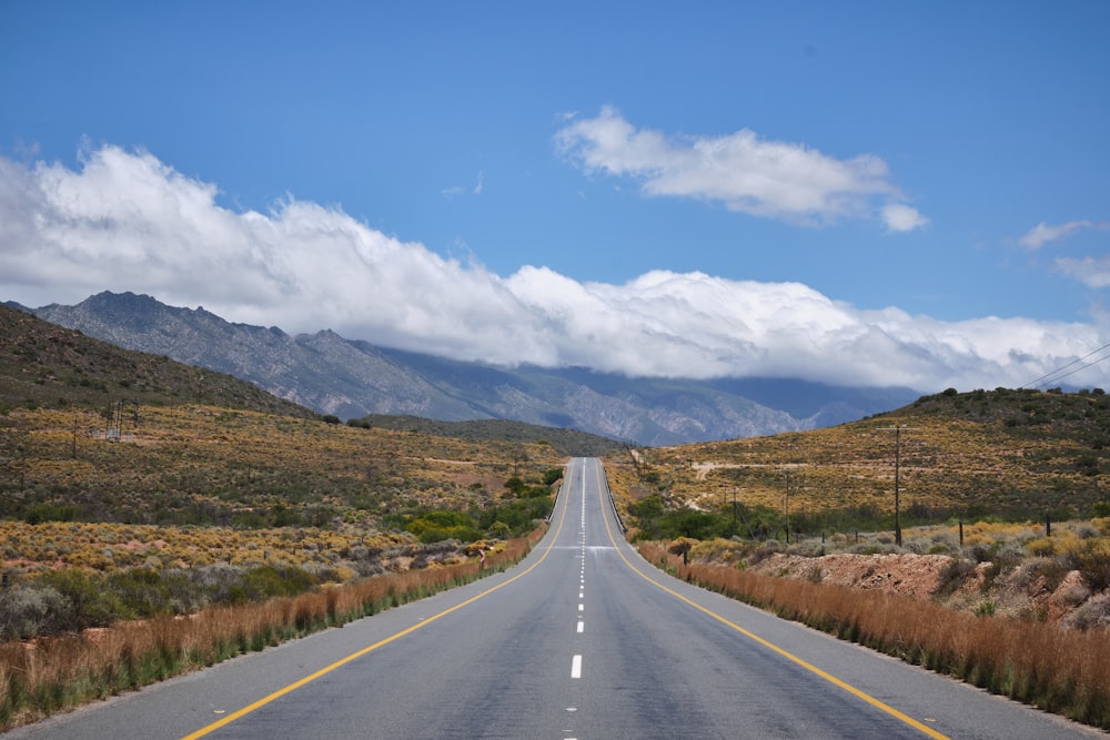 uma estrada vazia com montanhas ao fundo