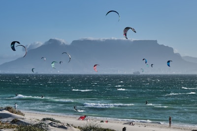 A panoramic view of a popular kitesurfing spot with mountains in the distance.