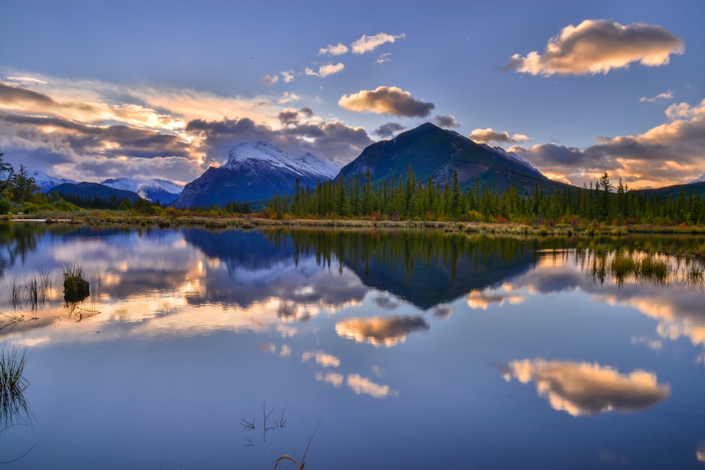 a lake with mountains in the background and clouds in the sky