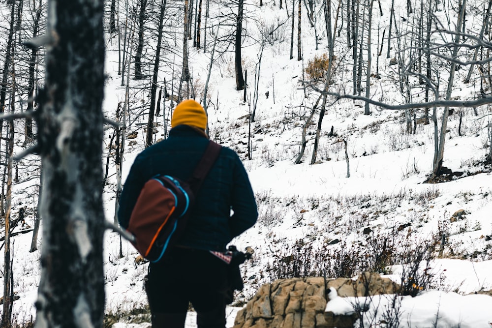 a man with a backpack is walking through the woods