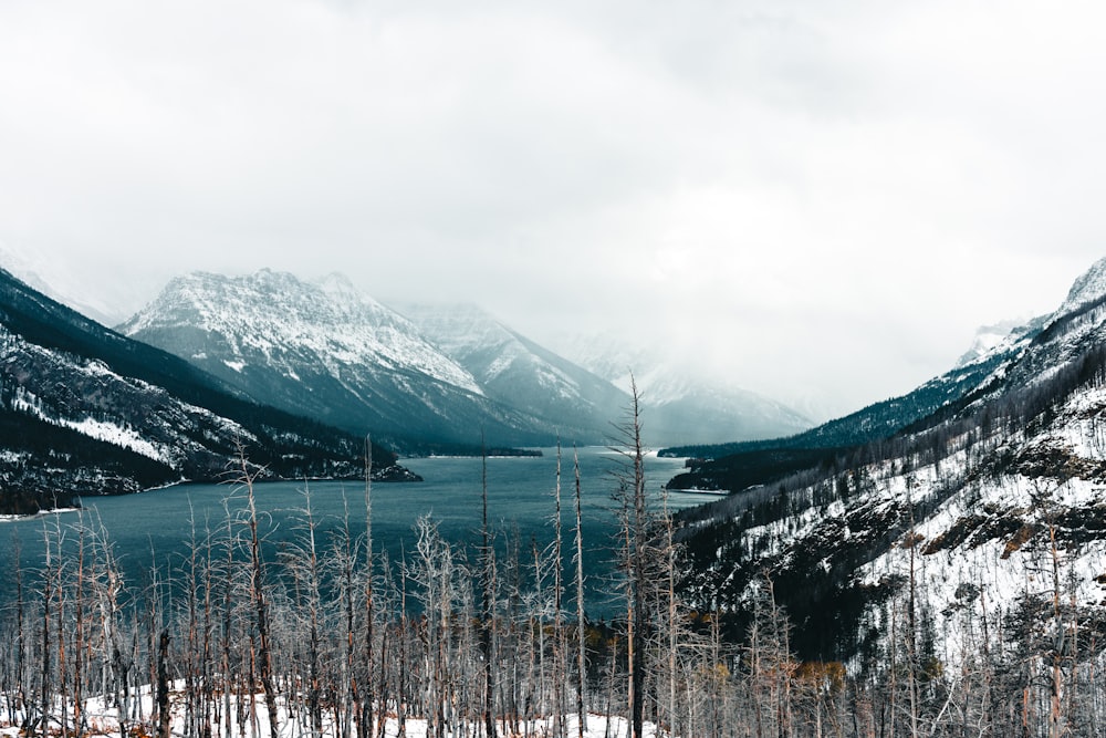 a view of a lake surrounded by snow covered mountains