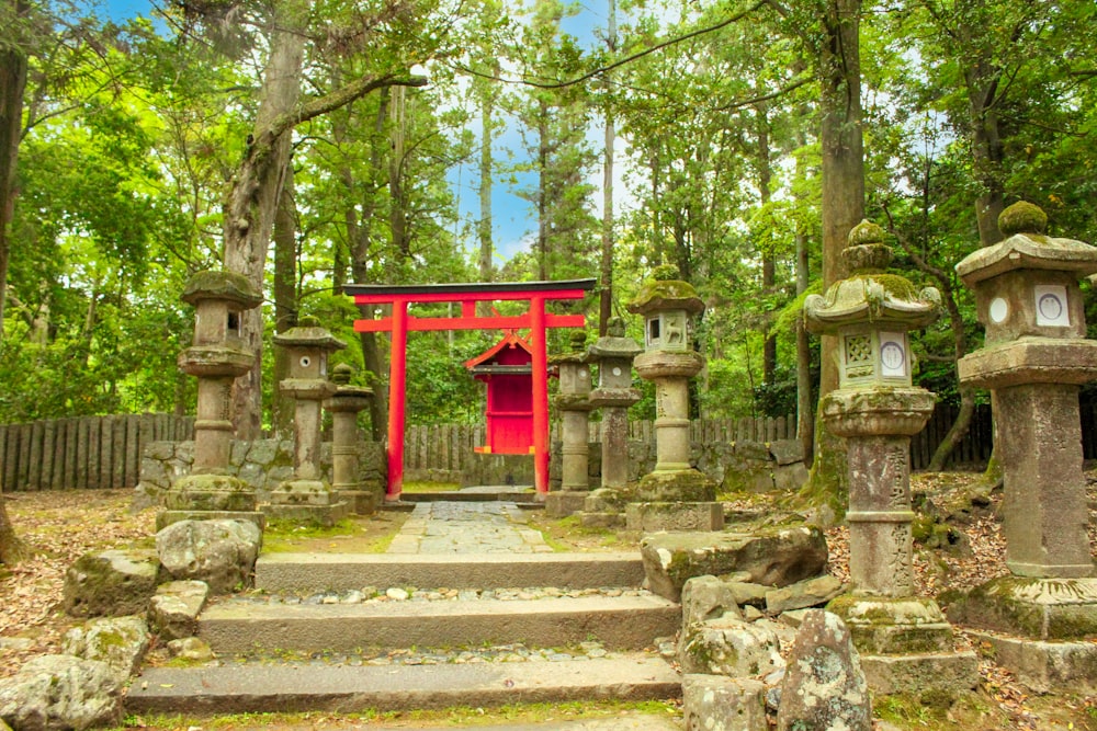 um portão vermelho no meio de uma floresta
