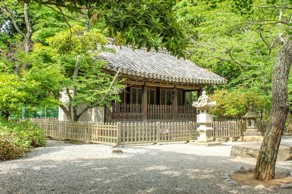 a small wooden building surrounded by trees in a park