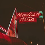 Colorful billboard advertisement for a local Mexican restaurant at sunset.