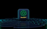 An icon with the logo of ChatGPT is placed at the center, standing out against a dark, futuristic, circular layered background with blue lighting accents.