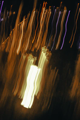 Abstract light trails in neon purple weaving through a dark urban setting.