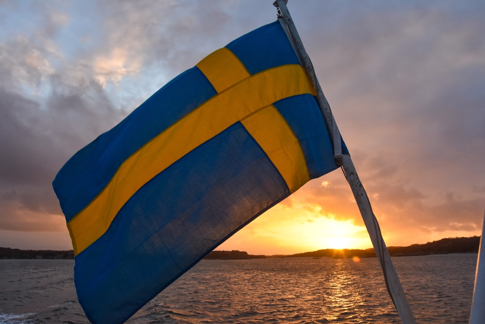 a blue and yellow flag on a boat in the water