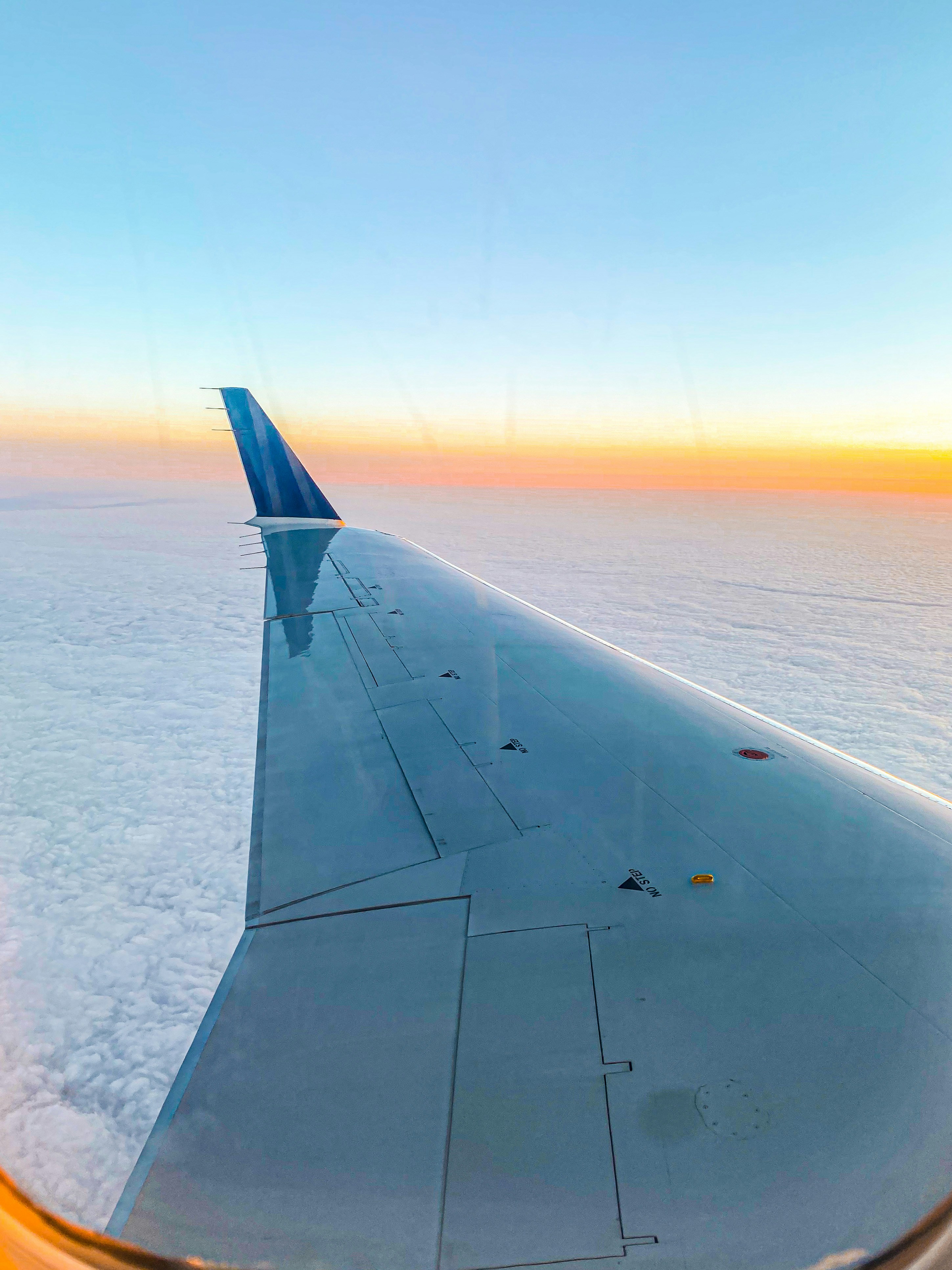 Der Flügel eines Flugzeugs, das über den Wolken fliegt