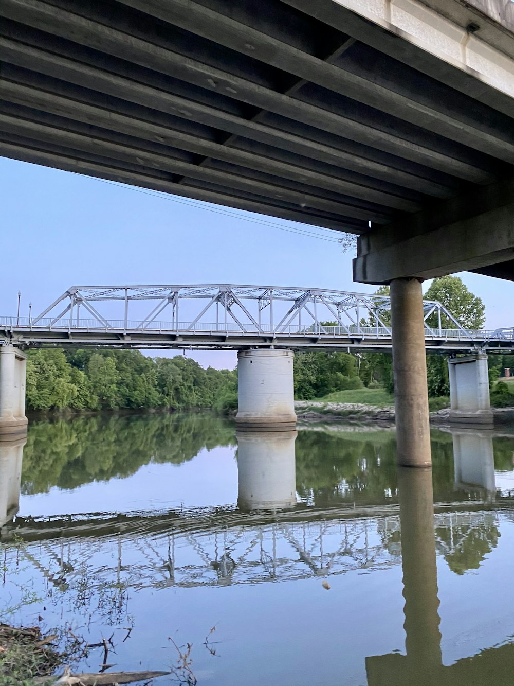 a bridge over a body of water with trees in the background