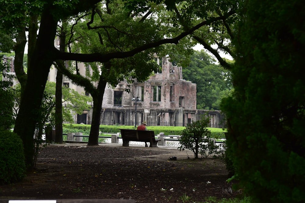 a person sitting on a bench in a park