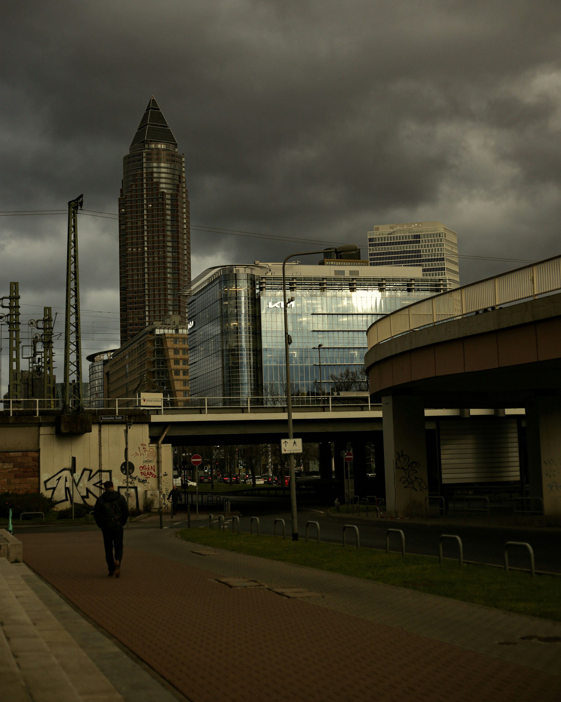 a man walking down a sidewalk next to a tall building