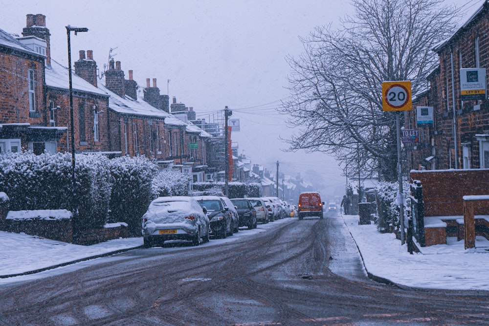 a snowy street with cars parked on the side of it