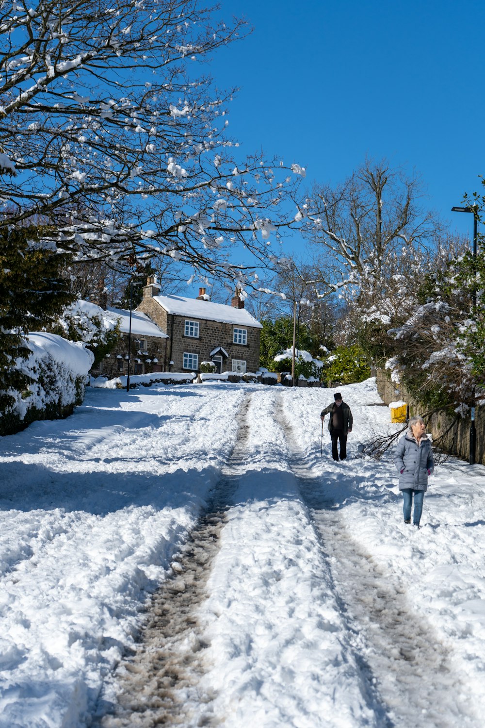 two people walking down a snow covered road
