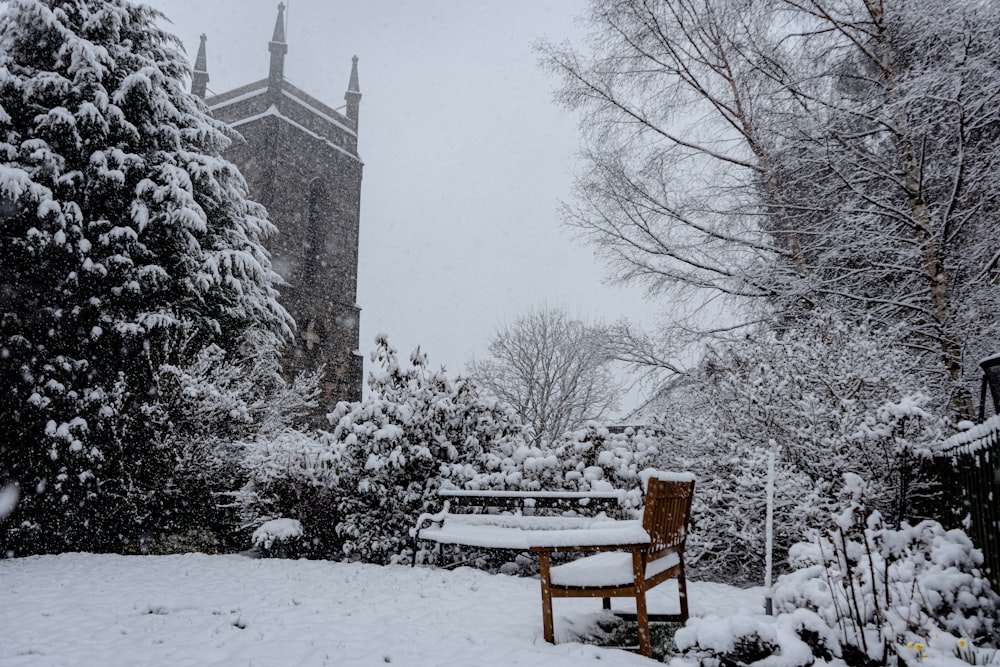 a bench covered in snow next to a tall building