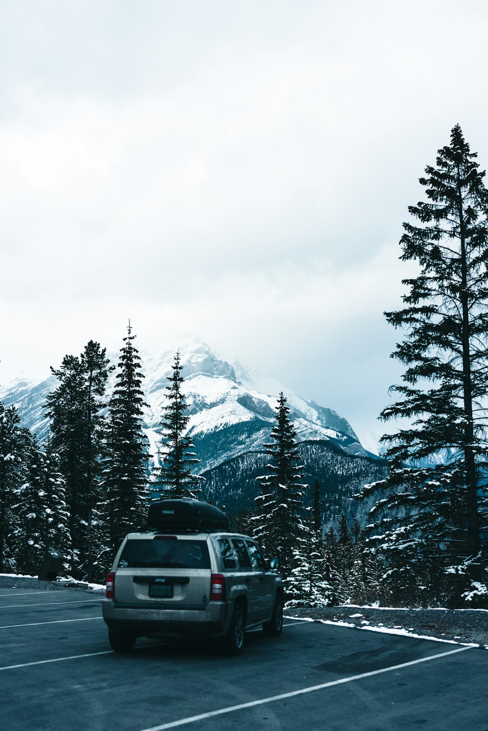 a car parked in a parking lot with a mountain in the background