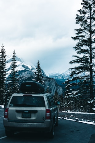 Close-up of a shiny silver SUV with polished rims on a mountain road.