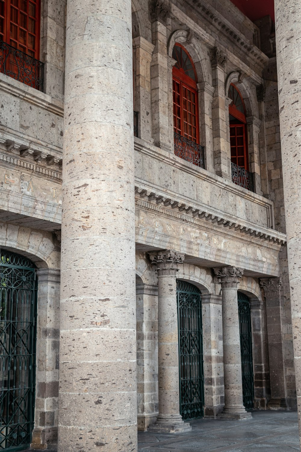 an old building with two large columns and a clock on the front of it