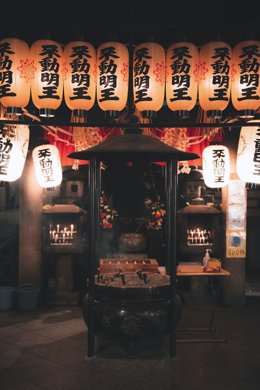 a chinese shrine with lanterns hanging above it