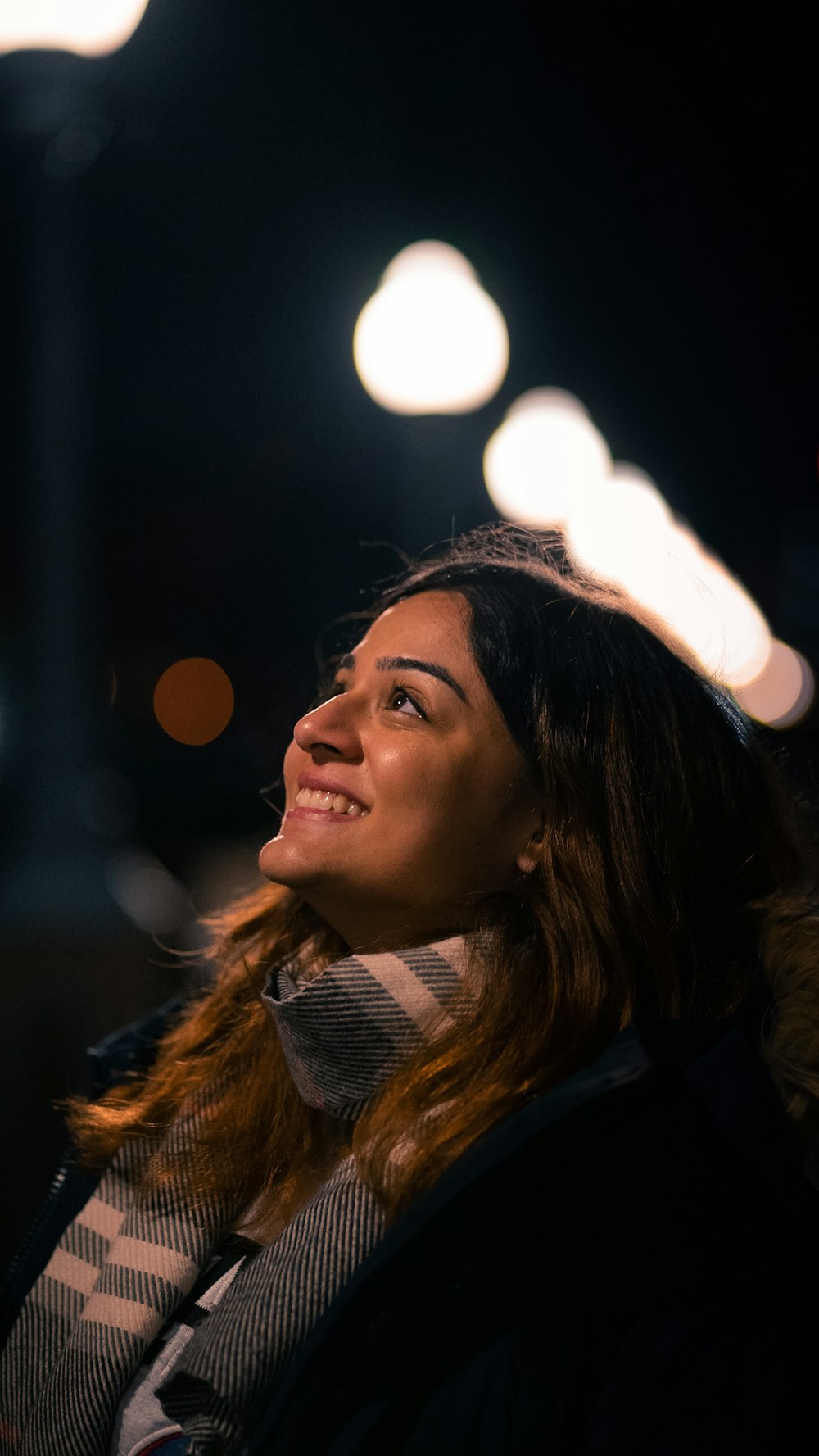 a woman standing in front of a street light at night