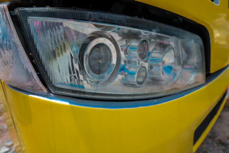 a close up of a headlight on a yellow car