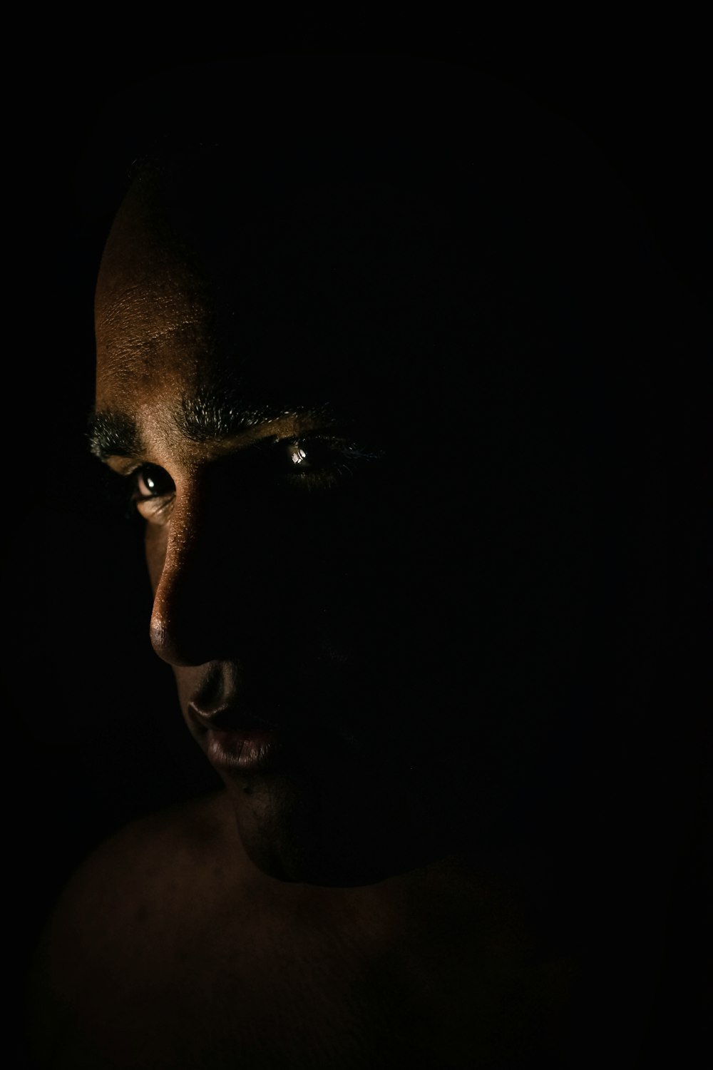 a man's face is shown in the dark