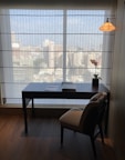 a desk and chair in a room with a large window