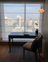 a desk and chair in a room with a large window